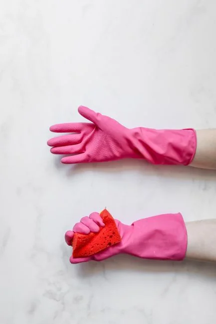 services-04 Anonymous male wearing yellow latex gloves and dark t shirt wiping mirror in bathroom with paper napkin